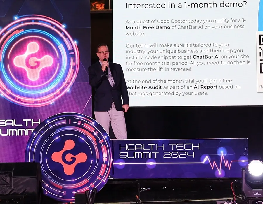 Ryan McClure, Managing Director of TWOMC Digital, presenting ChatBar AI at the Health Tech Summit 2024 in Jakarta. The on-screen display promotes a 1-month free demo offer for ChatBar AI.